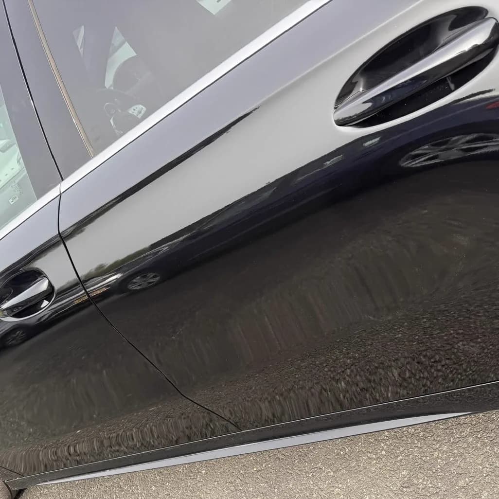 Black vehicle door after a professional scratch repair